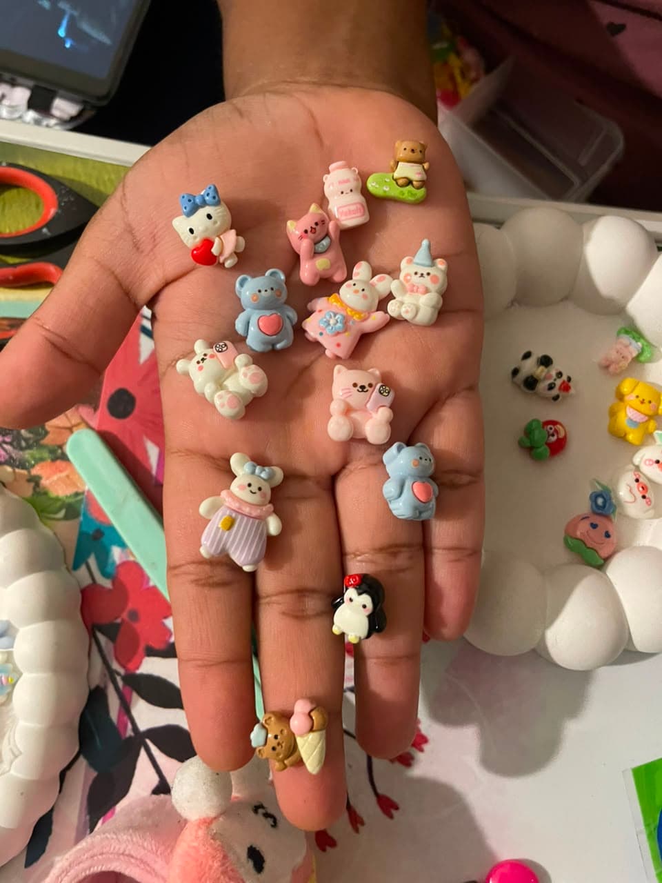 A handful of tiny decoden charms, ready to be placed by hand
